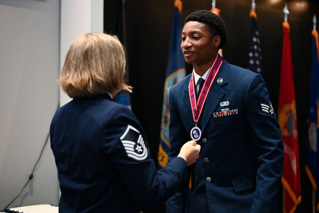 U.S. Air Force Senior Airman Verdelis Gillard, 17th Communications Squadron technician, receives his medallion from Master Sgt. Kristin Hingstrum, Goodfellow Airman Leadership School commandant, during the Airman Leadership School Class 25-D Graduation Ceremony at the Powell Event Center, Goodfellow Air Force Base, Texas, May 22, 2025. ALS equips Airmen with the skills to lead and manage in dynamic, complex and uncertain environments. (U.S. Air Force photo by Senior Airman Evelyn J. D’Errico)