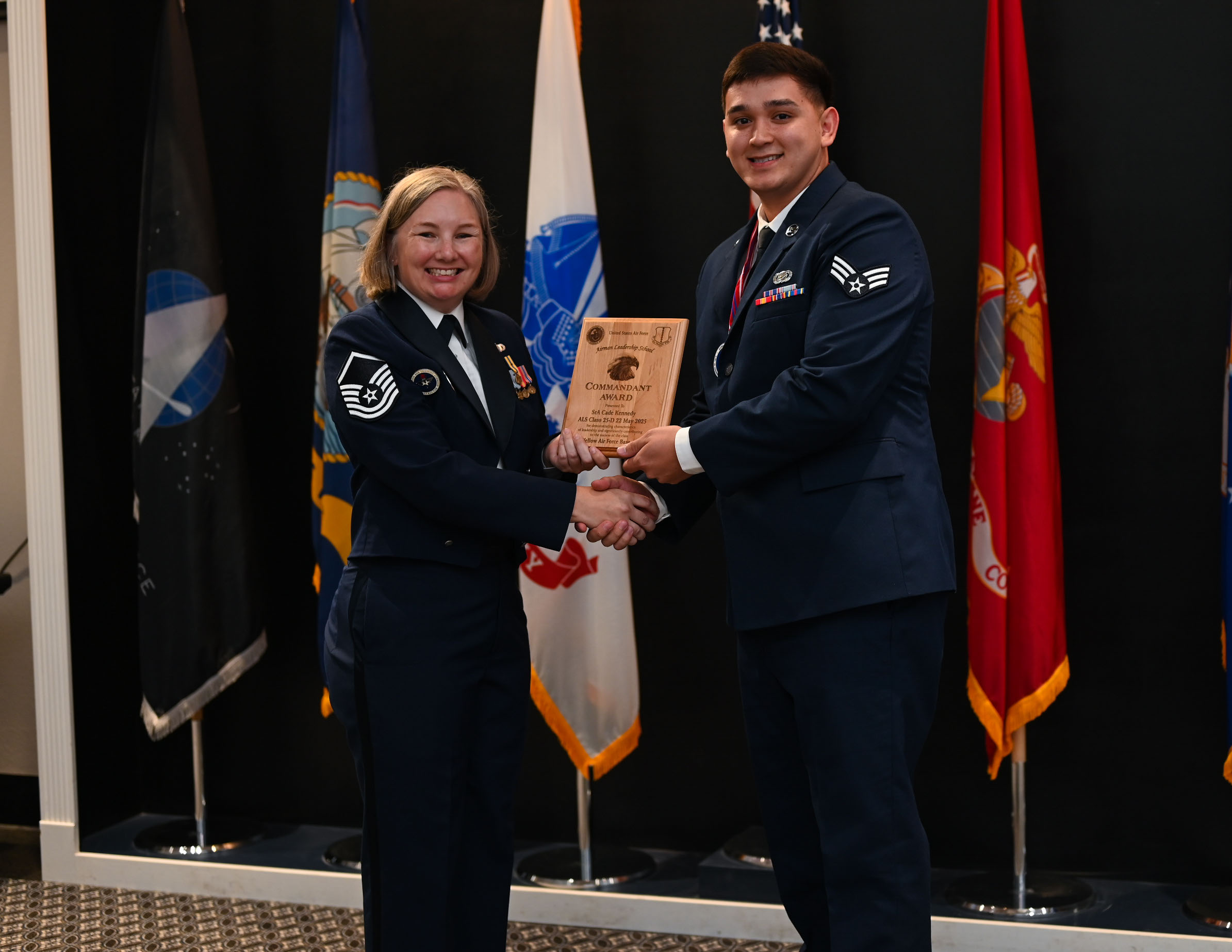Senior Airman Cade Kennedy, 17th Force Support Squadron personnelist, receives the Airman Leadership Commandant award from Master Sgt. Kristin Hingstrum, Goodfellow Airman Leadership School commandant, during the Airman Leadership School Class 25-D Graduation Ceremony at the Powell Event Center, Goodfellow Air Force Base, Texas, May 22, 2025. ALS equips Airmen with the skills to lead and manage in dynamic, complex and uncertain environments. (U.S. Air Force photo by Senior Airman Evelyn J. D’Errico)