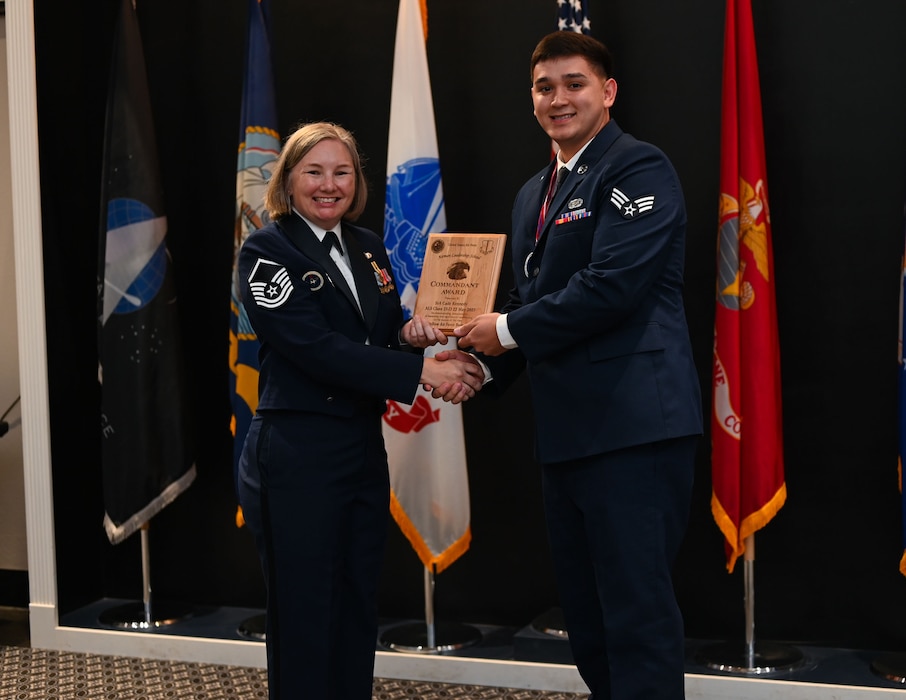 Senior Airman Cade Kennedy, 17th Force Support Squadron personnelist, receives the Airman Leadership Commandant award from Master Sgt. Kristin Hingstrum, Goodfellow Airman Leadership School commandant, during the Airman Leadership School Class 25-D Graduation Ceremony at the Powell Event Center, Goodfellow Air Force Base, Texas, May 22, 2025. ALS equips Airmen with the skills to lead and manage in dynamic, complex and uncertain environments. (U.S. Air Force photo by Senior Airman Evelyn J. D’Errico)