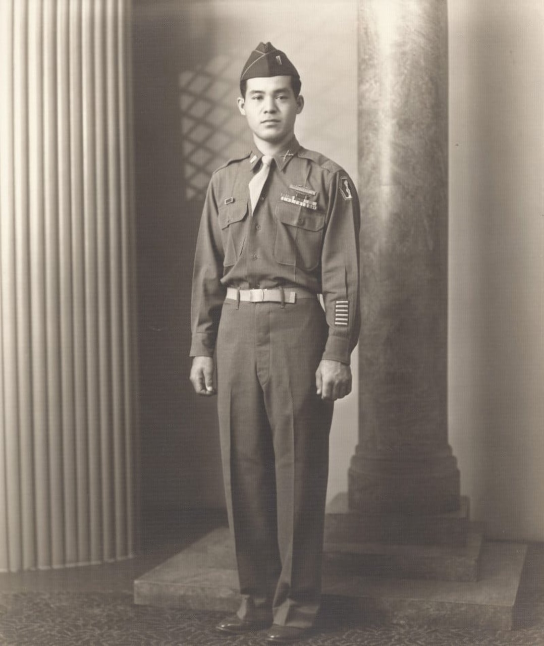 A man in uniform stands at attention, looking at the camera.