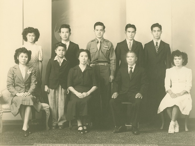 Ten people, four of whom are seated, pose for a photo.