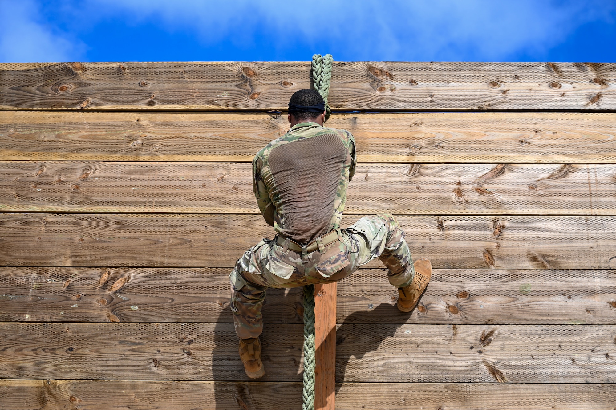 Photo of an Airman rappelling down a wall during an advanced combat skills assessment
