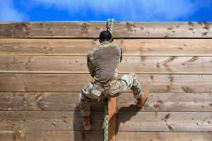 Photo of an Airman rappelling down a wall during an advanced combat skills assessment
