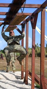 Photo of an Airman swinging to a plank during an advanced combat skills assessment