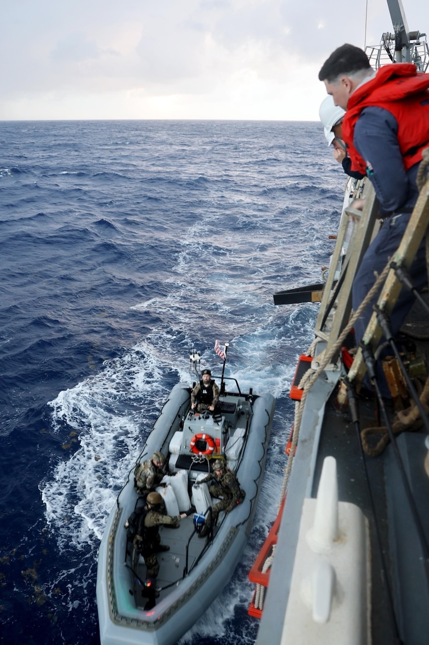 Coast Guardsmen assigned to U.S. Coast Guard Law Enforcement Detachment (LEDET) 401, and Sailors assigned to the Arleigh Burke-class guided-missile destroyer USS Gravely (DDG 107), prepare to transfer bails of cocaine seized during a maritime interdiction operation (MIO) while underway in the Caribbean Sea.
