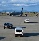Cars drive out to airplanes on a flightline