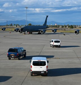 Cars drive out to airplanes on a flightline