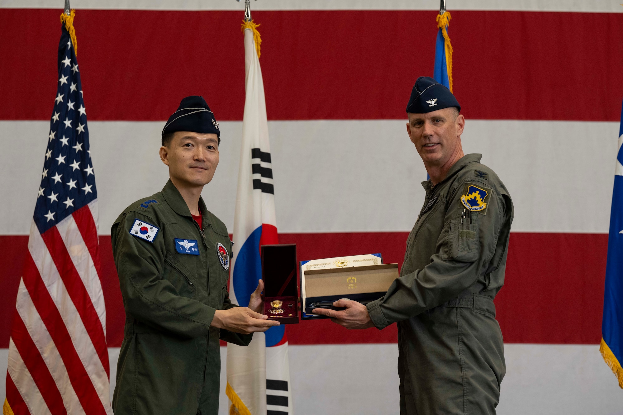 Republic of Korea Air Force Col. Yang - Jae, Ham, 38th Fighter Group commander, presents a presidential watch and Order of National Security Merit Samil Medal on behalf of the acting president of the Republic of Korea, President Lee Ju-Ho, to U.S. Air Force Col. Peter Kasarskis during the 8th Fighter Wing change of command ceremony at Kunsan Air Base, Republic of Korea, May 30, 2025.