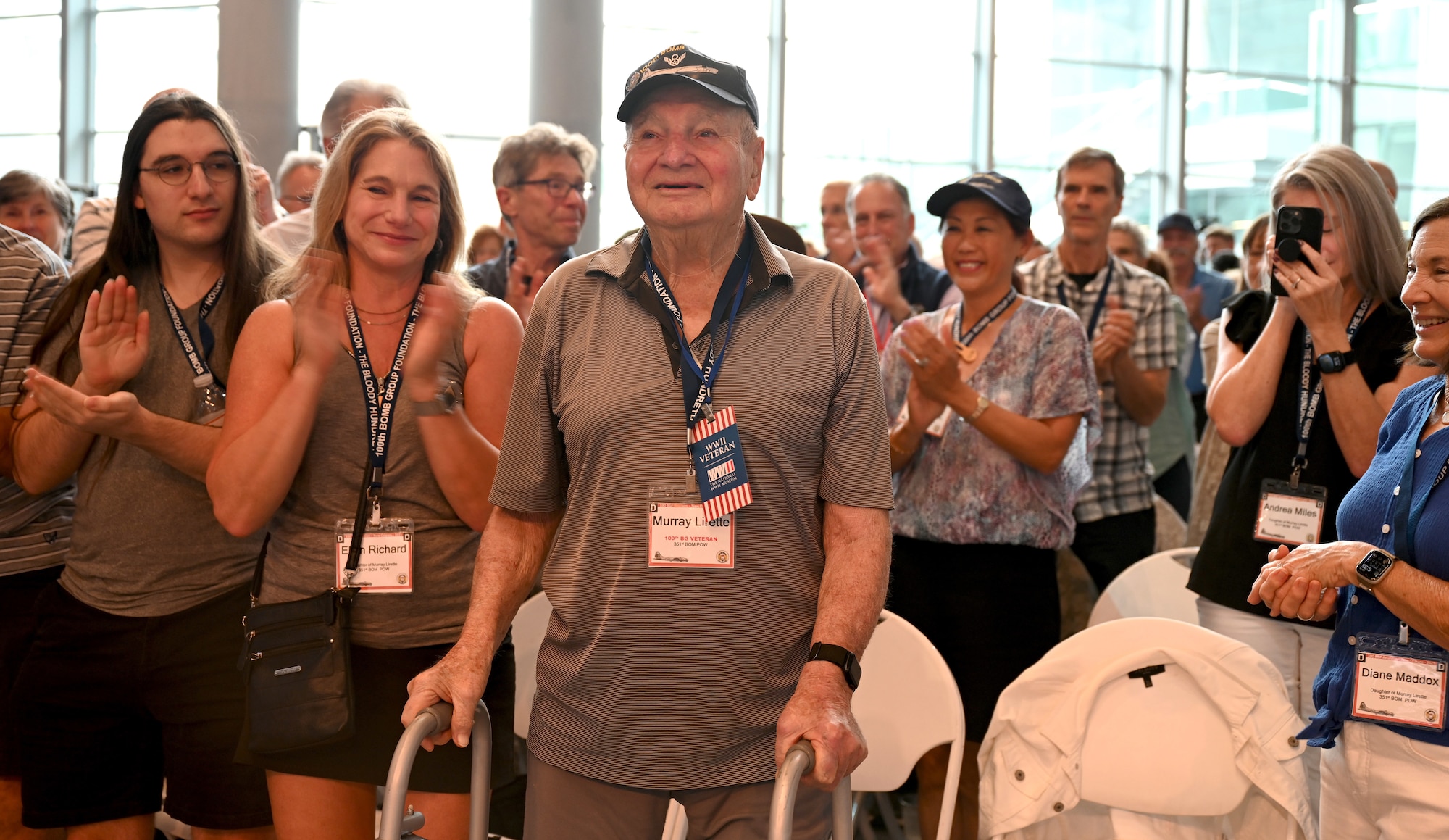 U.S. Army Air Corps 2nd Lt. Murray Lirette, center, 100th Bomb Group and 351st Bomb Squadron bombardier, stands to a round of applause in his honor after being recognized as a prisoner of war during World War II at the 100th BG reunion in New Orleans, La., May 16, 2025. Lirette was one of three World War II veterans who attended the reunion, held every other year at a different location within the United States. (U.S. Air Force photo by Karen Abeyasekere)