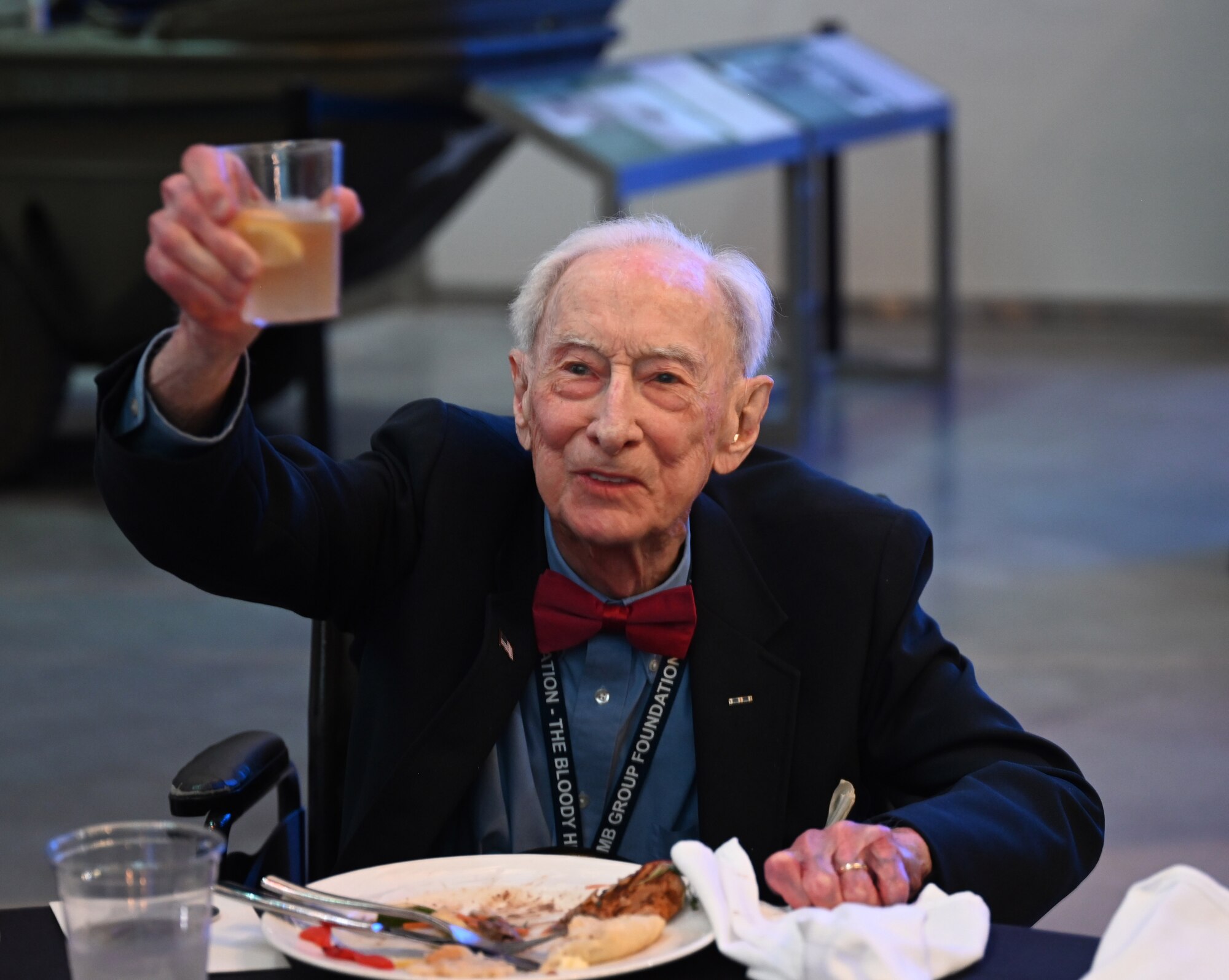 U.S. Army Air Corps Maj. John “Lucky” Luckadoo, World War II and 100th Bomb Group 351st Bomb Squadron pilot and Veteran, raises a glass to attendees at the 100th Bomb Group reunion in thanks for their support of the Bloody Hundredth at the National World War II Museum, New Orleans, La., May 17, 2025. Luckadoo is 103 years old and flew 25 combat missions out of Thorpe Abbotts, England, during World War II. (U.S. Air Force photo by Karen Abeyasekere)