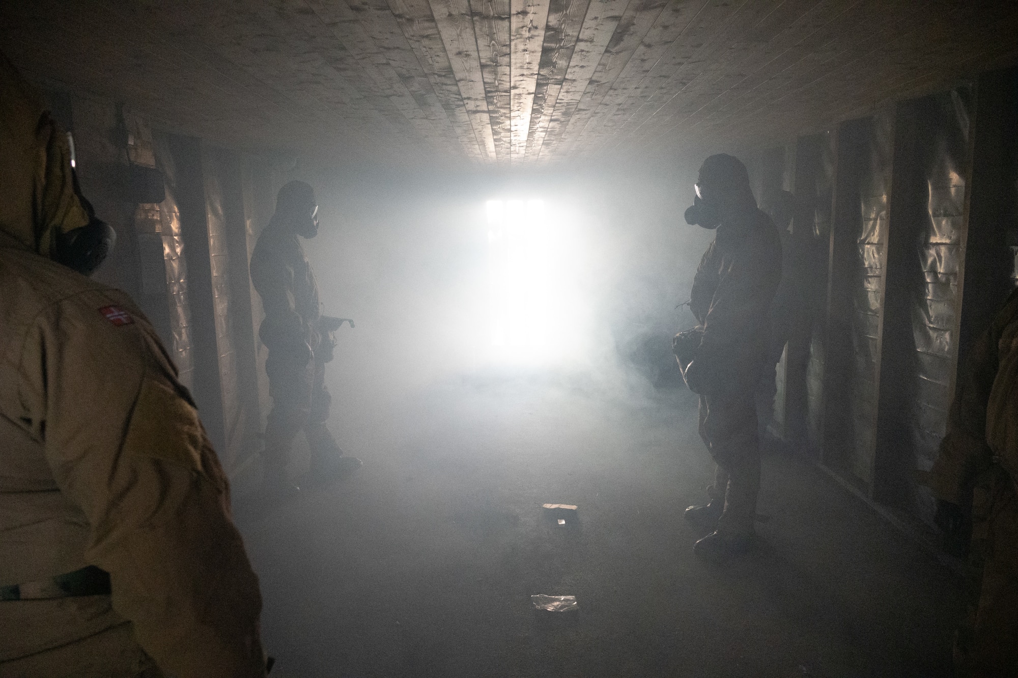 U.S. Airmen from the 426th Air Base Squadron stand inside a gas chamber in full protective gear