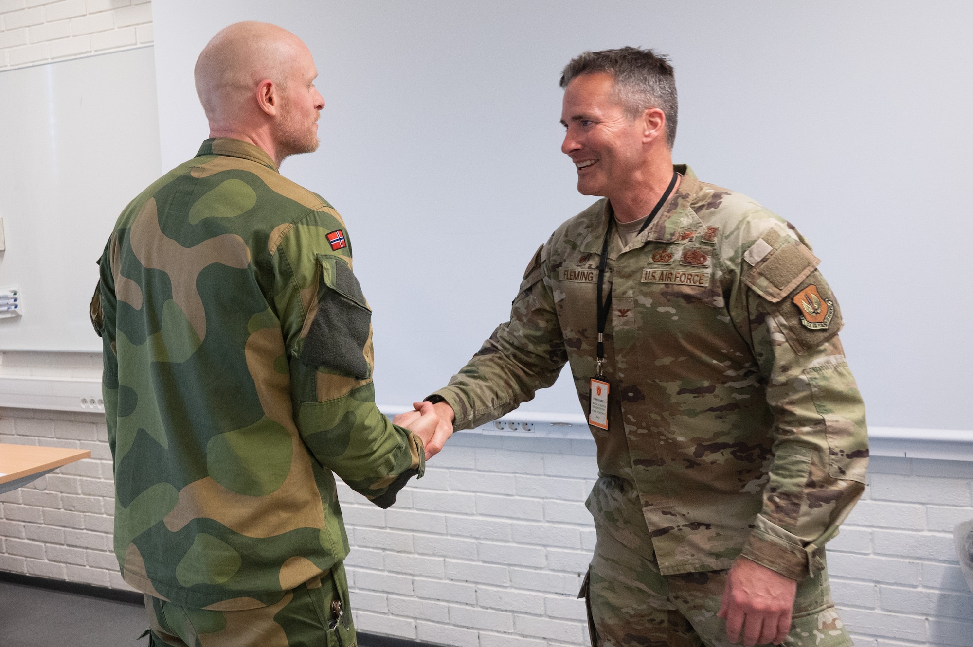 U.S. Air Force Col. Michael G. Fleming, 423rd Air Base Group commander, presents a coin to Royal Norwegian Navy Chief Petty Officer Dag Tore