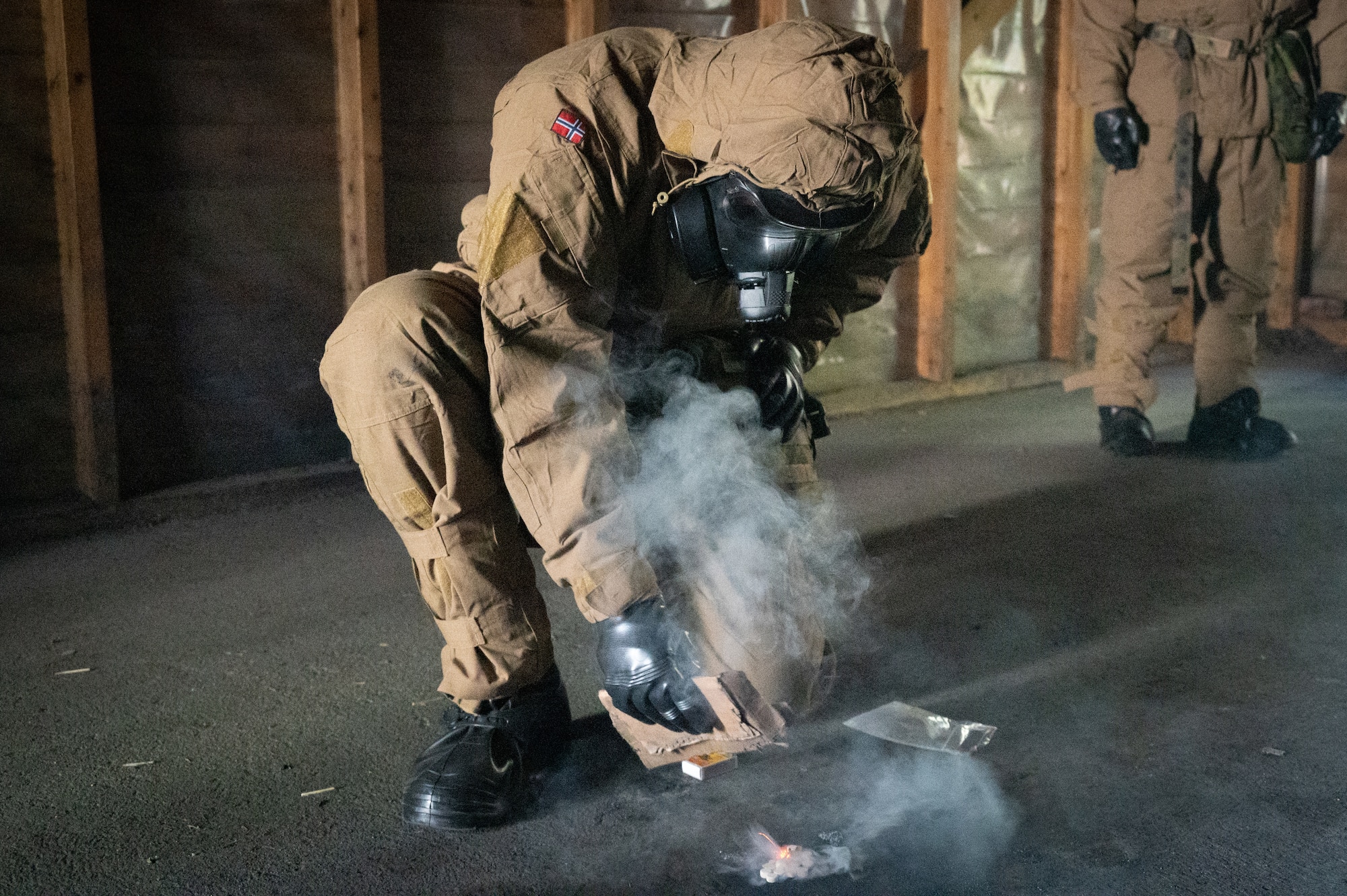 A Royal Norwegian Navy instructor ignites tear gas tablets