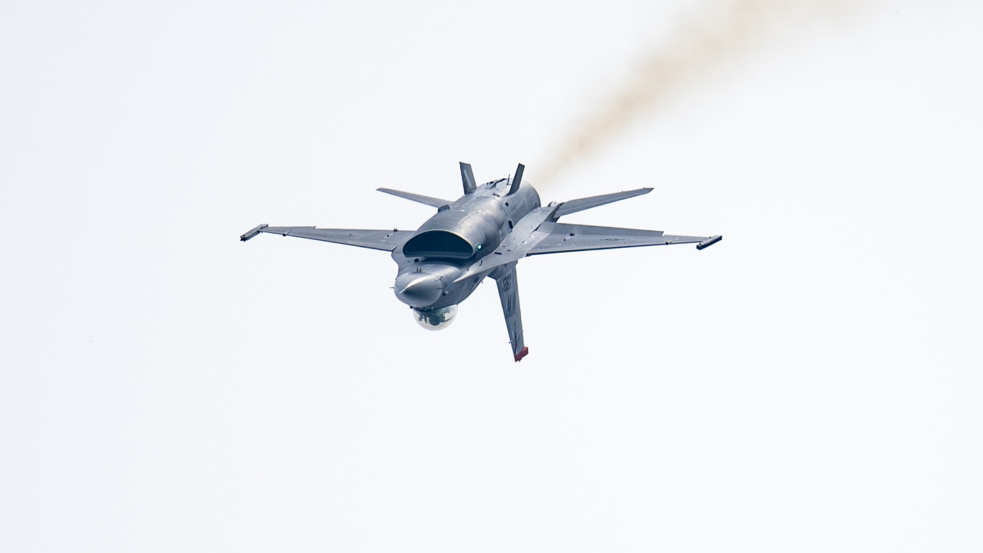 inverted F-16 fighter jet flies through the air