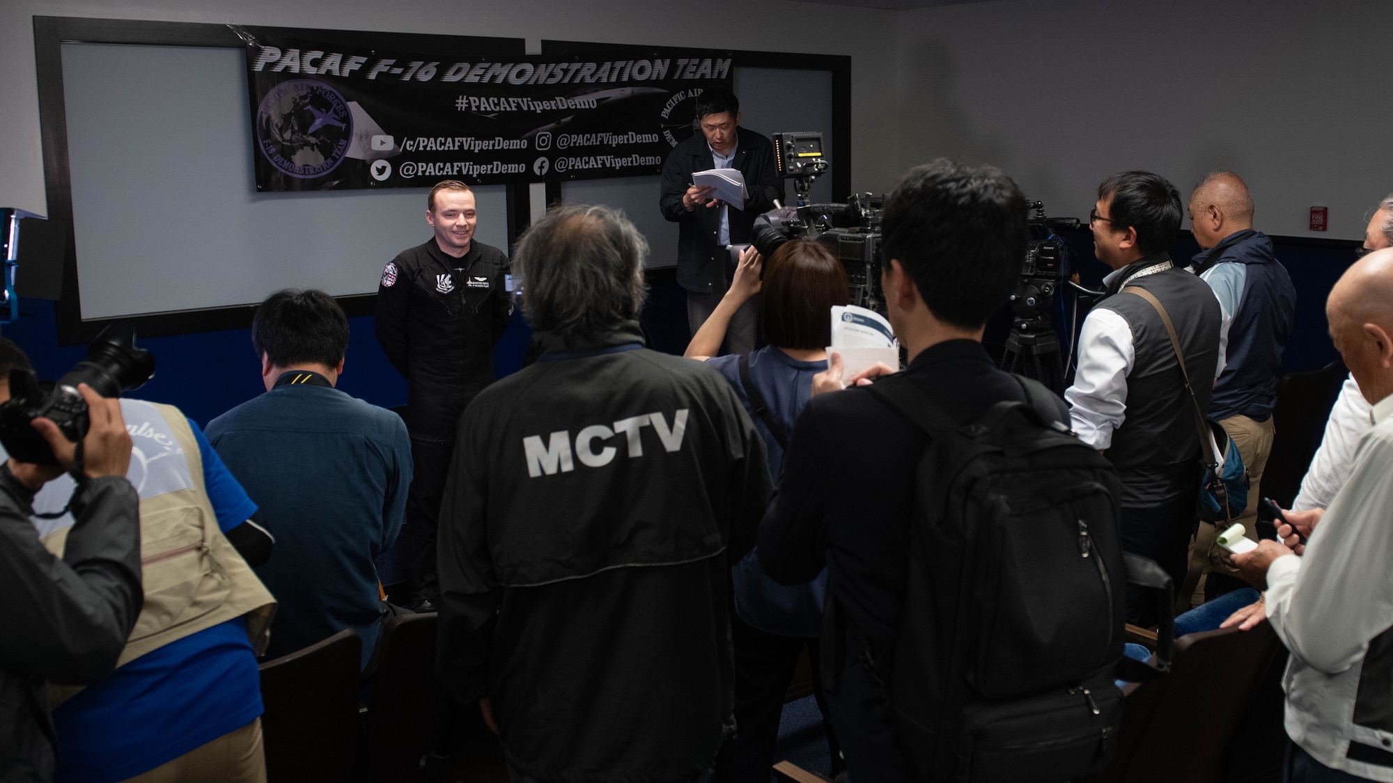 pilot stands in front of a media press conference