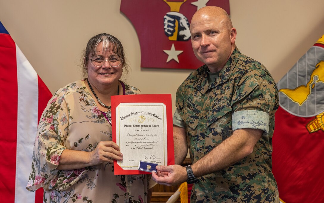 Linda Brown, the awards manager with Headquarters Battalion, 2d Marine Division, poses for a photo with U.S. Marine Corps Maj. Gen. Farrell Sullivan on Marine Corps Base Camp Lejeune, North Carolina, May 28, 2025. Mrs. Brown received the Federal Length of Service Award in appreciation and recognition of her 30 years of service to the federal government. (U.S. Marine Corps photo by Pfc. Oscar Ocampo)