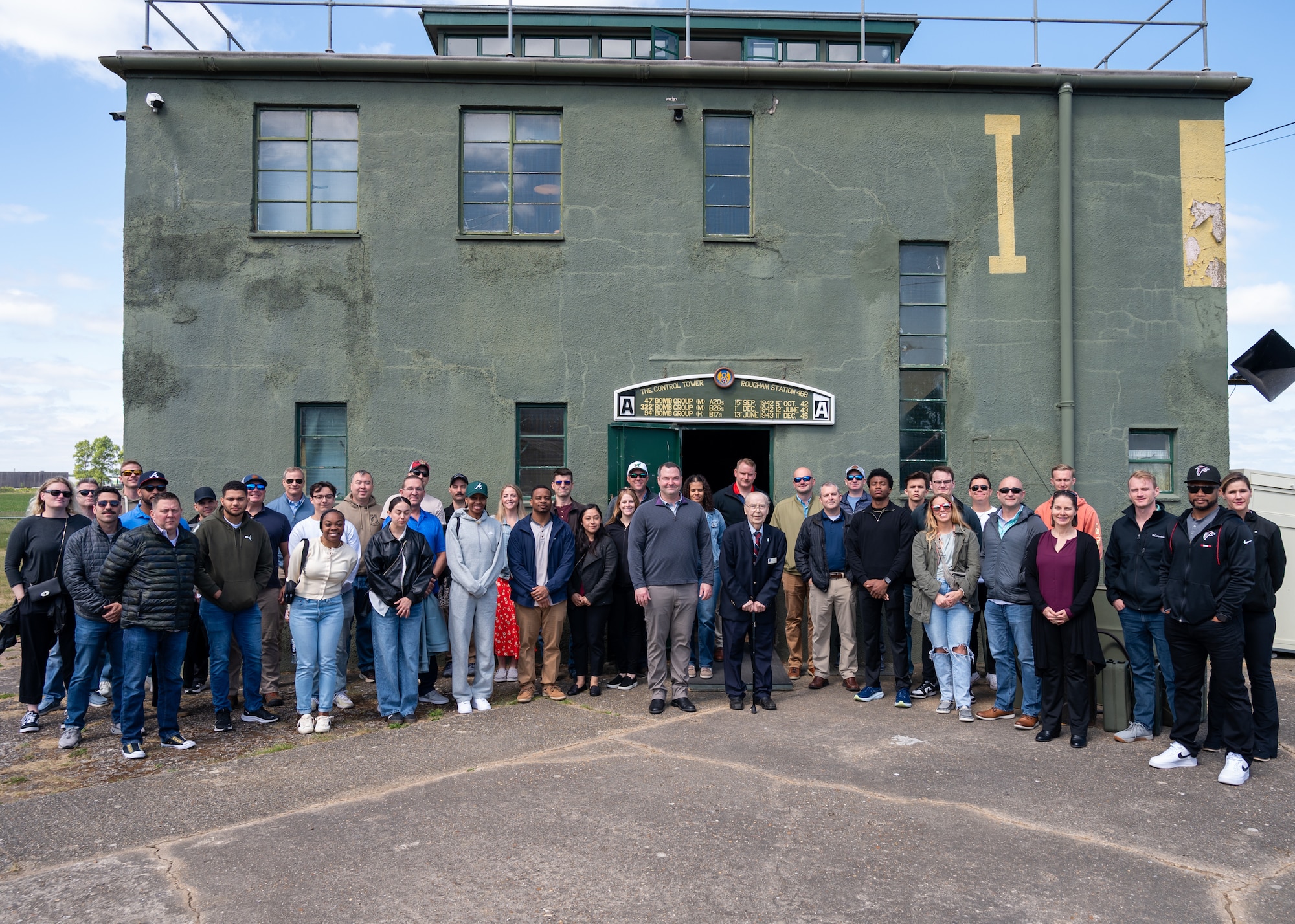 A group of people pose outside the restored Rougham Control Tower museum