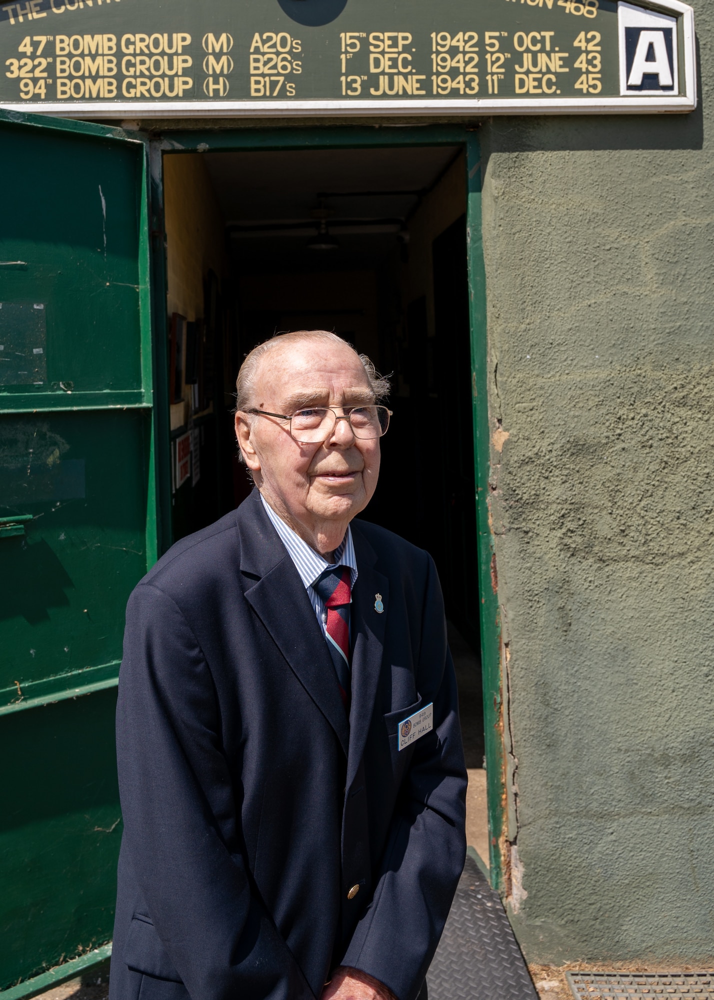 An elderly gentleman stands outside a museum
