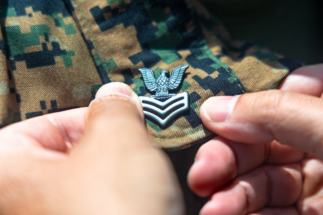 U.S. Navy Senior Chief Hospital Corpsman Michael Devito, the medical senior enlisted leader for the 26th Marine Expeditionary Unit and a native of Virginia, pins on the rank insignia of Petty Officer 1st class onto Reigious Program Specialist 1st Class Dominic Cicale, a Sailor with the 26th Marine Expeditionary Unit and a native of Illinois, during his frocking ceremony at Camp Lejeune, North Carolina, May 29, 2025. Promotion ceremonies highlight a significant achievement in a service member's career and are a testament to their commitment, master of duties and skills, and leadership capabilities. (U.S. Marine Corps Photo by Lance Cpl. Jack Labrador)