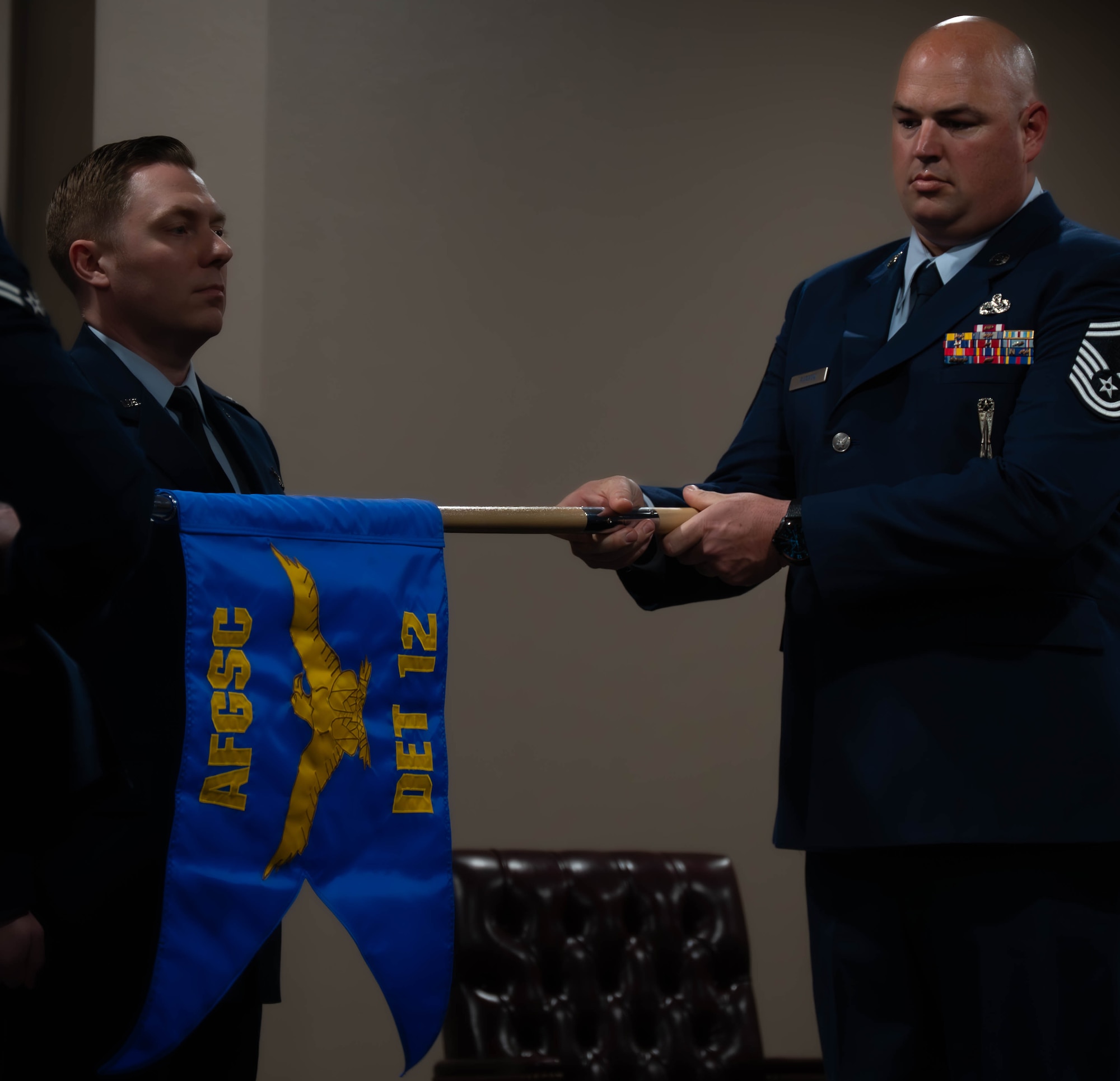 Senior Master Sgt. Jonathan Barron, Air Force Global Strike Command strategic deterrence and nuclear integration member, unwraps the new Detachment guidon at the Site Activation Task Force for Detachment 12. SATAF detachments are tasked with laying the groundwork for Sentinel support operations by overseeing and coordinating transition and establishment activities. (U.S. Air Force photo by Senior Airman Alexander Nottingham)