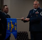 Senior Master Sgt. Jonathan Barron, Air Force Global Strike Command strategic deterrence and nuclear integration member, unwraps the new Detachment guidon at the Site Activation Task Force for Detachment 12. SATAF detachments are tasked with laying the groundwork for Sentinel support operations by overseeing and coordinating transition and establishment activities. (U.S. Air Force photo by Senior Airman Alexander Nottingham)