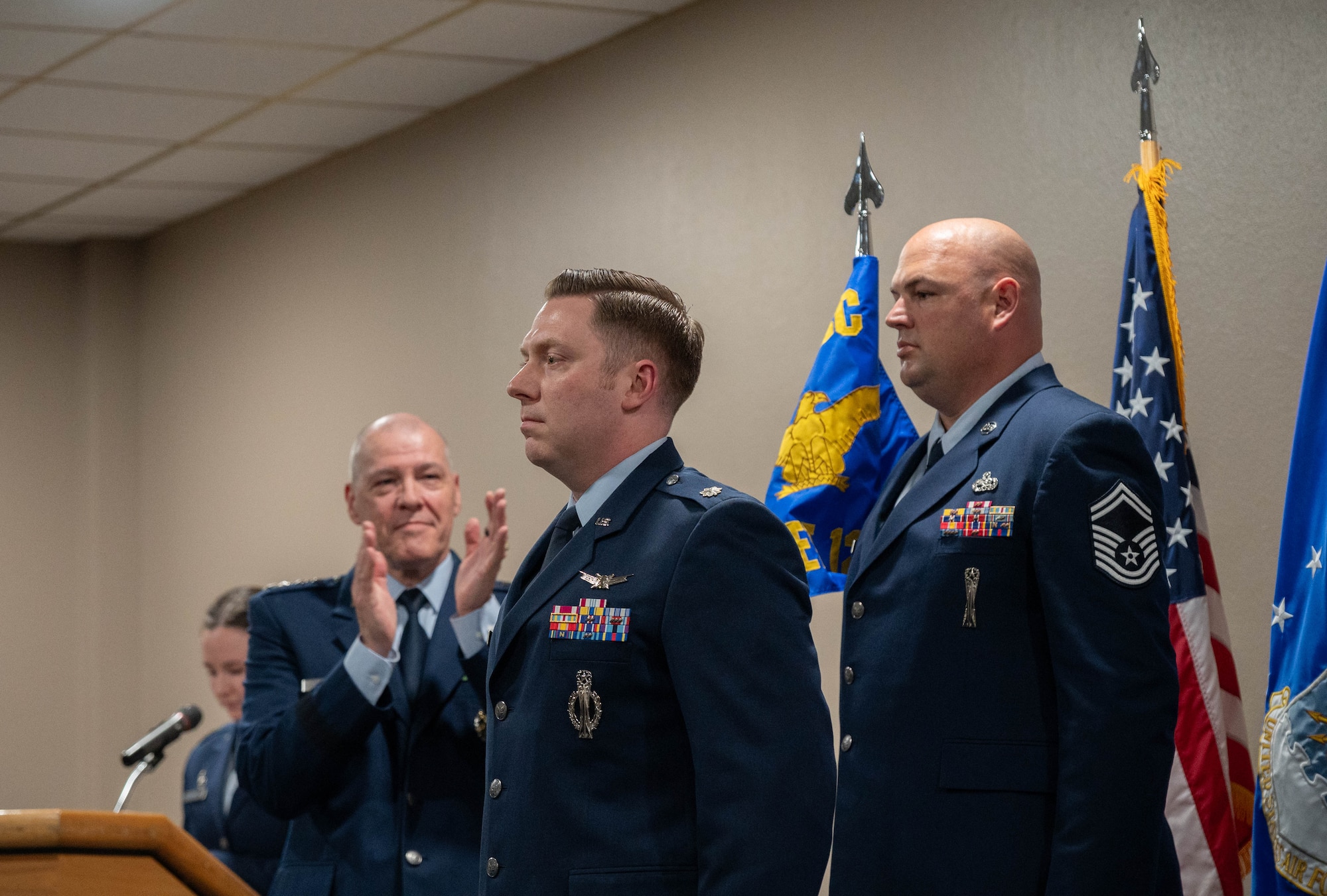 U.S. Air Force Gen. Thomas A. Bussiere, Air Force Global Strike Command commander, (left) prepares to present to Lt. Col. Nicholas Conover, Site Activation Task Force Detachment 12 commander, (middle) the Detachment 12 guidon at Minot Air Force Base, North Dakota, May 21, 2025. SATAF detachments are tasked with laying the groundwork for Sentinel support operations by overseeing and coordinating transition and deployment activities. (U.S. Air Force photo by Airman 1st Class Wesley Davies)