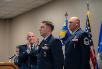 U.S. Air Force Gen. Thomas A. Bussiere, Air Force Global Strike Command commander, (left) prepares to present to Lt. Col. Nicholas Conover, Site Activation Task Force Detachment 12 commander, (middle) the Detachment 12 guidon at Minot Air Force Base, North Dakota, May 21, 2025. SATAF detachments are tasked with laying the groundwork for Sentinel support operations by overseeing and coordinating transition and deployment activities. (U.S. Air Force photo by Airman 1st Class Wesley Davies)