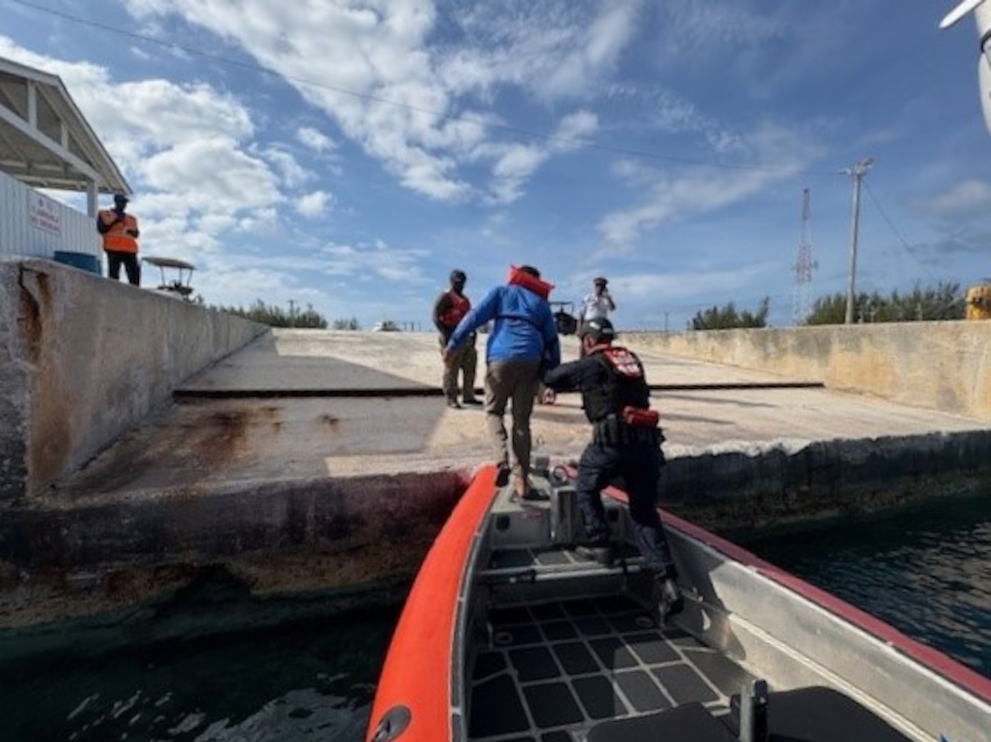 A boat crew from the Coast Guard Cutter Margaret Norvell (WPC-1105) mooring alongside a pier in Freeport, Bahamas, May 30, 2025. The crew transferred the survivor to the Royal Bahamas Defense Force after he was rescued from a capsized vessel approximately eight miles offshore. (U.S. Coast Guard photo)