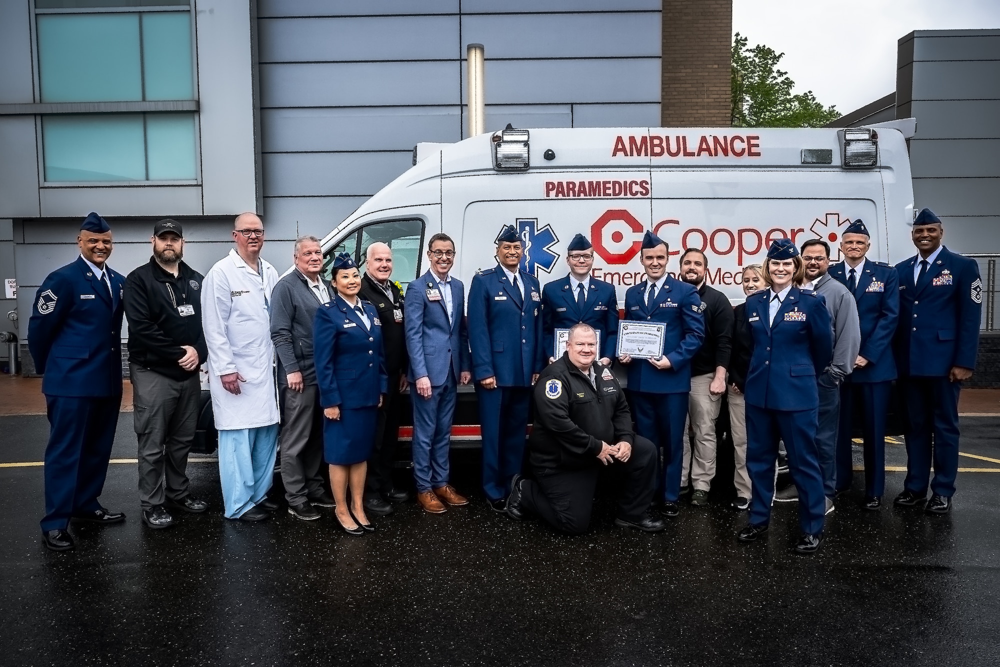 87th Air Base Wing personnel and Cooper University Hospital staff pose for a photo following the inaugural Air Force Paramedic Currency Platform graduation ceremony at Camden, N.J., May 22, 2025. The ceremony was held to commemorate the successful completion of the paramedic currency platform at Cooper University Hospital by two Airmen assigned to the 87th Healthcare Operations Squadron. (Courtesy photo by Avi Steinhardt)