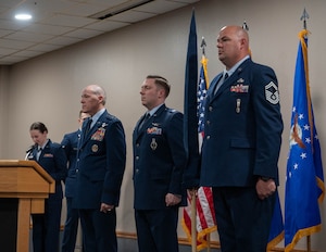 U.S. Air Force Gen. Thomas A. Bussiere, Air Force Global Strike Command commander, (left) prepares to present to Lt. Col. Nicholas Conover, Site Activation Task Force Detachment 12 commander, (middle) the Detachment 12 guidon at Minot Air Force Base, North Dakota, May 21, 2025. SATAF detachments are tasked with laying the groundwork for Sentinel support operations by overseeing and coordinating transition and deployment activities. (U.S. Air Force photo by Airman 1st Class Wesley Davies)