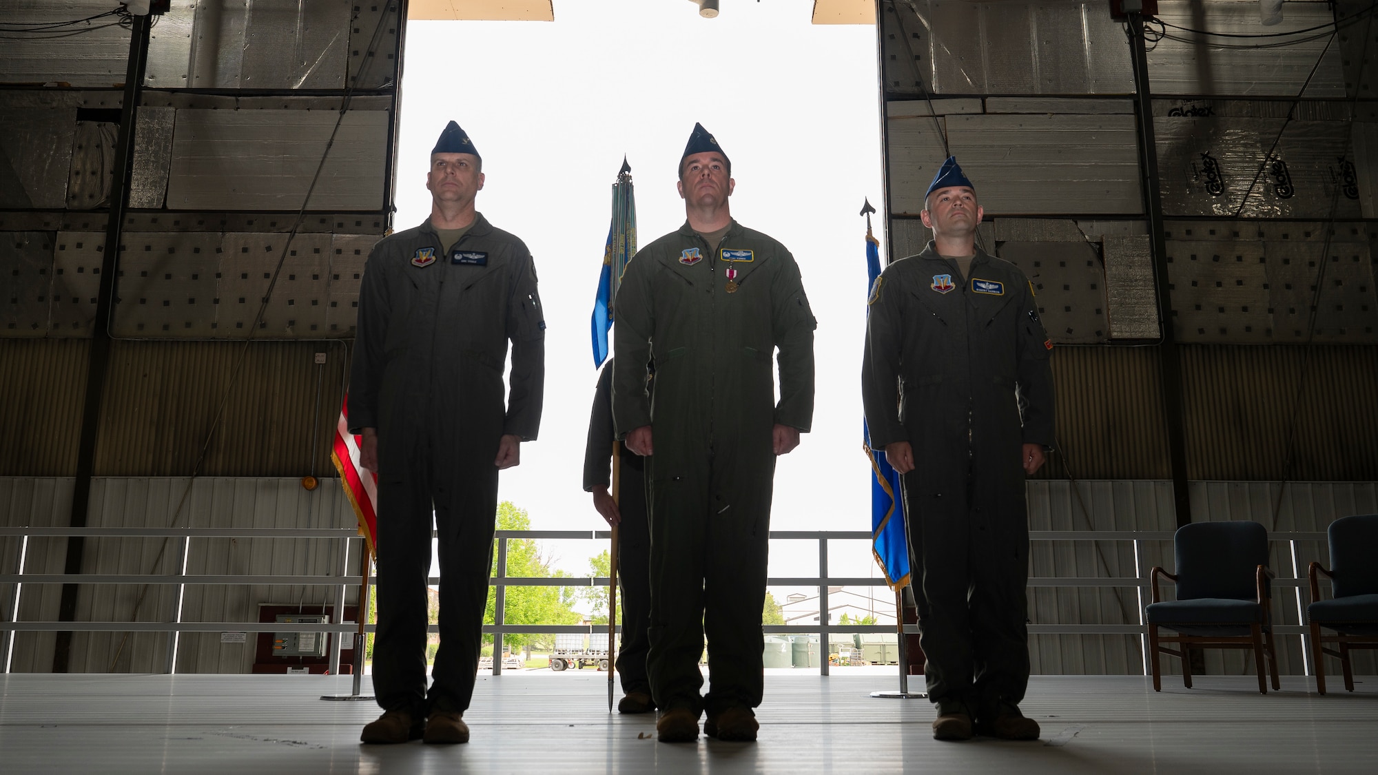 319th Operations Group leadership and 348th Reconnaissance Squadron leadership, stand at attention during the 348th RS change of command ceremony at Grand Forks Air Force Base, N.D., May 30, 2025. From left, Col. Eric Steele, 319th OG commander presided over the ceremony, transferring command from Lt. Col. Cory Turner, 348th RS outgoing commander to Lt. Col. Robert Damron, 348th RS incoming commander. (U.S. Air Force photo by Airman Nailah Pacheco)
