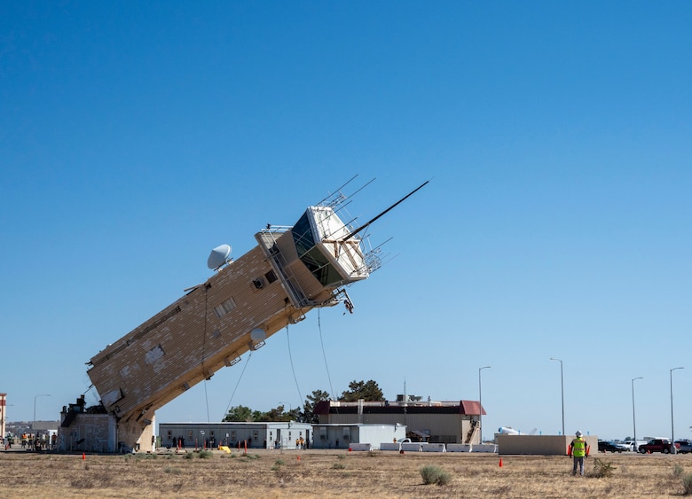 A decommissioned air traffic control tower at Plant 42 falls April 29 during its demolition at the Air Force installation in Palmdale, California. Crews used an excavator and cable system to safely bring down the structure, which had its support beams cut in advance.