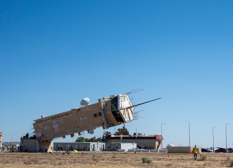 A decommissioned air traffic control tower at Plant 42 falls April 29 during its demolition at the Air Force installation in Palmdale, California. Crews used an excavator and cable system to safely bring down the structure, which had its support beams cut in advance.