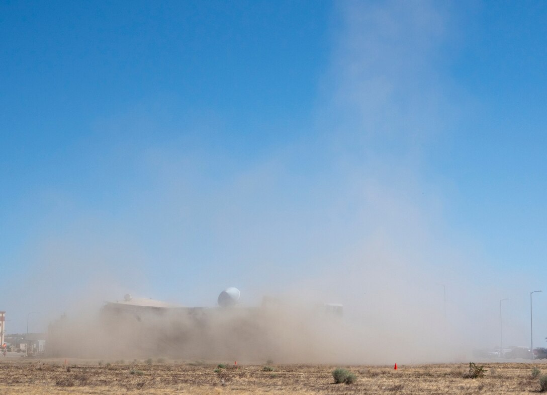 A decommissioned air traffic control tower at Plant 42 falls April 29 during its demolition at the Air Force installation in Palmdale, California. Crews used an excavator and cable system to safely bring down the structure, which had its support beams cut in advance.