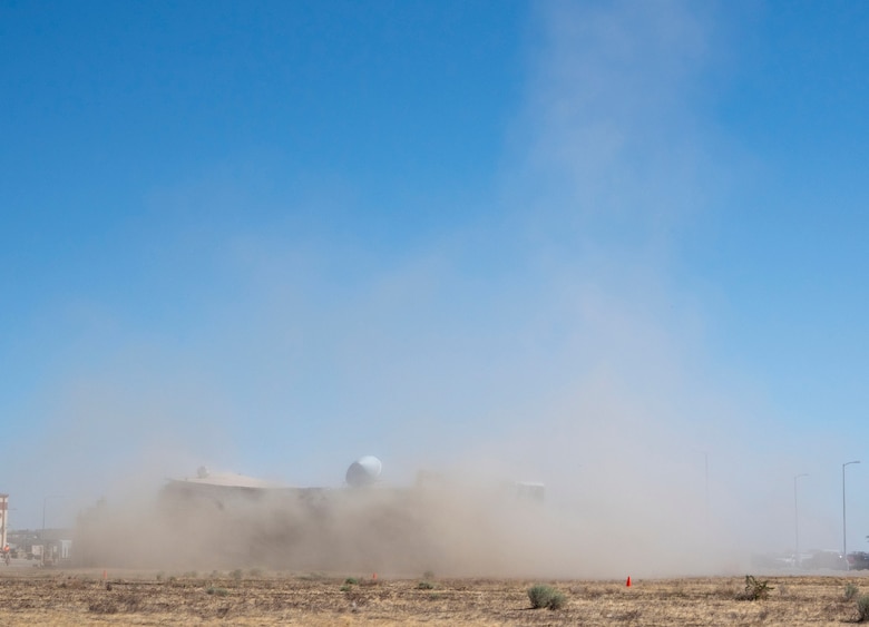 A decommissioned air traffic control tower at Plant 42 falls April 29 during its demolition at the Air Force installation in Palmdale, California. Crews used an excavator and cable system to safely bring down the structure, which had its support beams cut in advance.