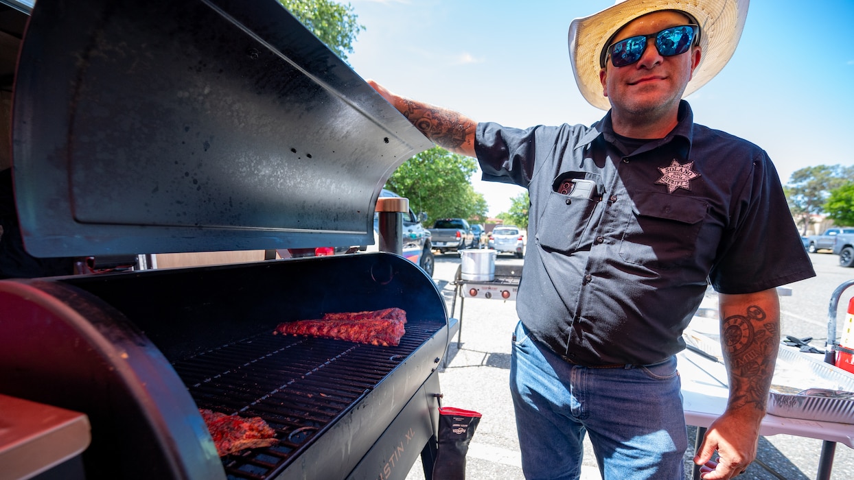 Police officer checks ribs in smoker