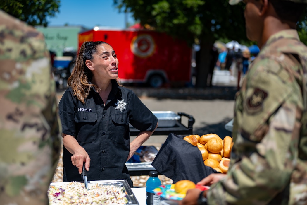 Sheriff's staff member serves food to Airmen during competition.