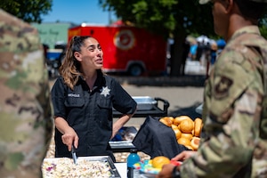 Sheriff's staff member serves food to Airmen during competition.
