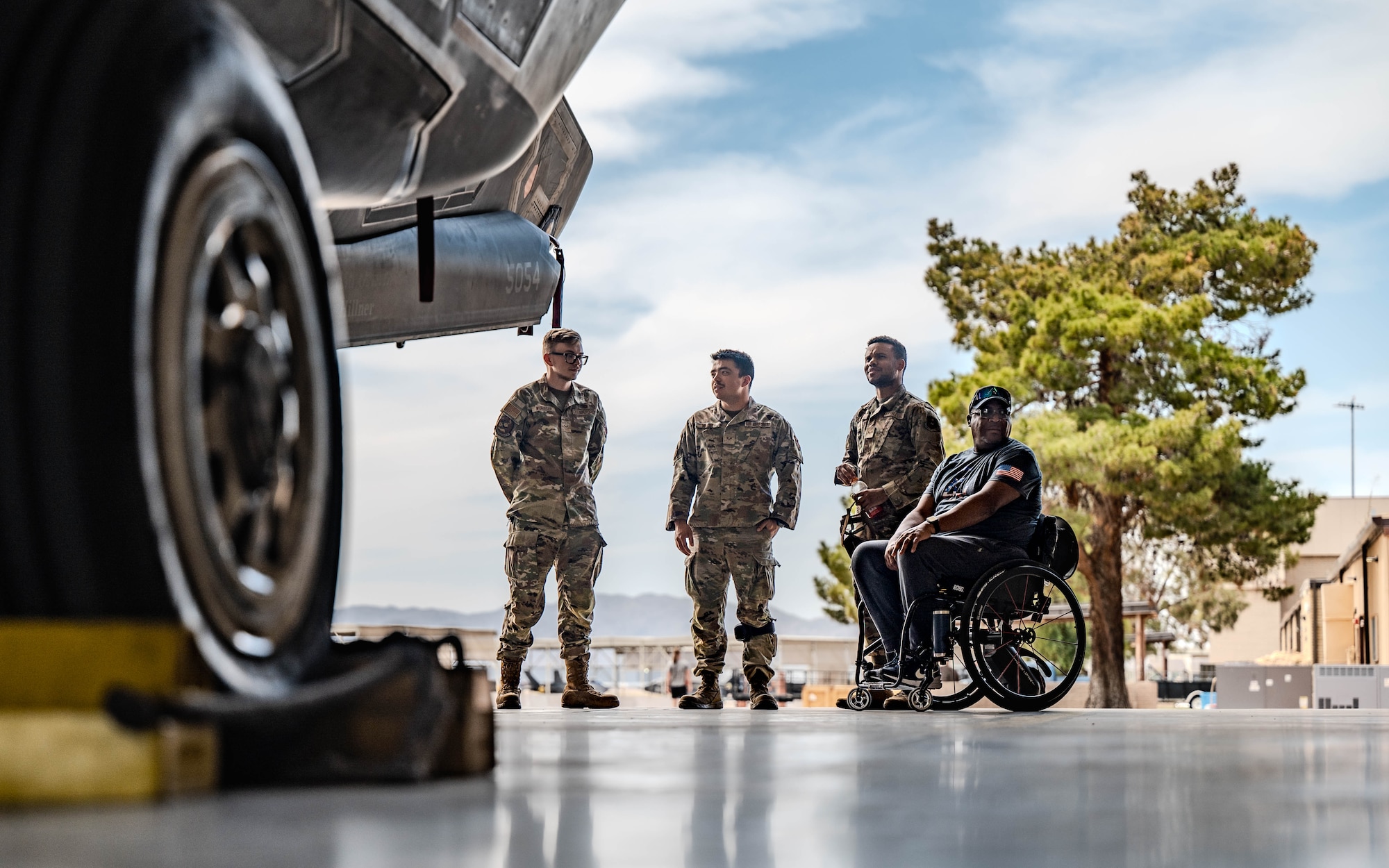 U.S. Air Force airmen assigned to the 62nd Aircraft Maintenance Unit stand alongside para-athlete Cedric Geter during an F-35A Lightning II tour