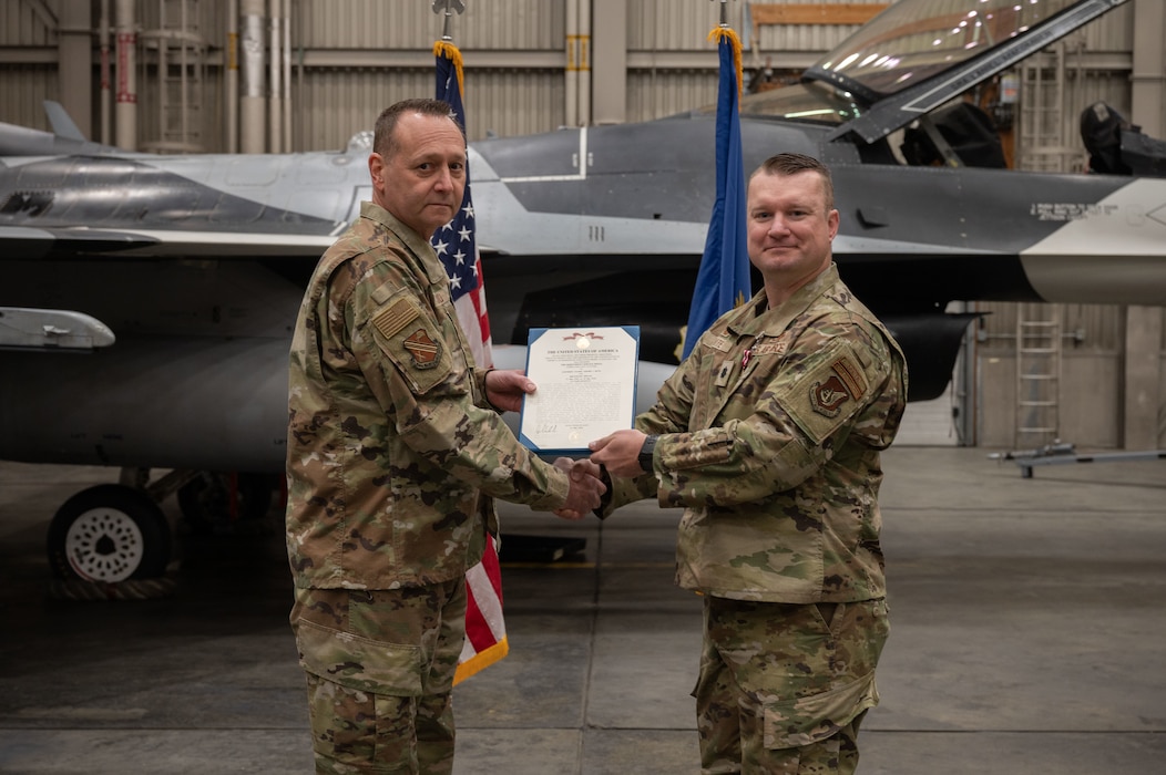 U.S. Air Force Lt. Col. Stephan White, right, 18th Fighter Generation Squadron outgoing commander, receives the Meritorious Service Medal from Col. Jerry Copeland, 354th Maintenance Group commander, during a change of command ceremony at Eielson Air Force Base, Alaska, May 30, 2025.