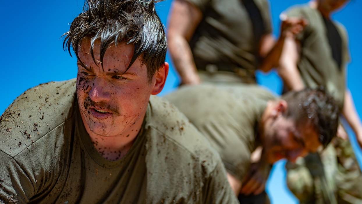 An Airman looks off with mud on his face