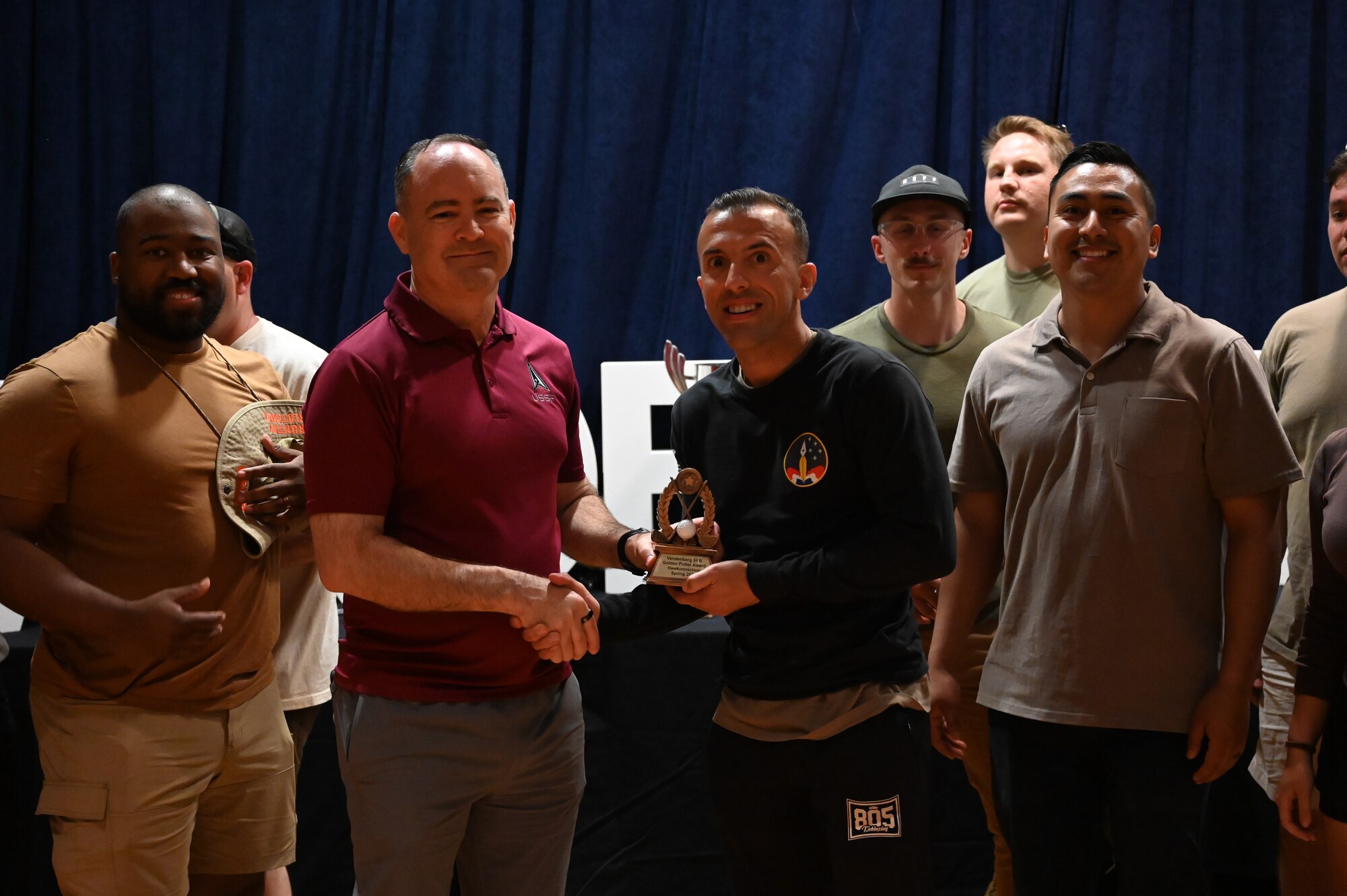 People pose for a photo on stage.