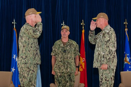 U.S. Navy Vice Adm. Scott Gray, commander, Navy Installations Command, center, officiates the turnover between Rear Adm. Brent DeVore, outgoing commander, Joint Region Marianas, right, and Rear Adm. Brett Mietus, incoming JRM commander, during a change of command ceremony at Guam High School, May 29.