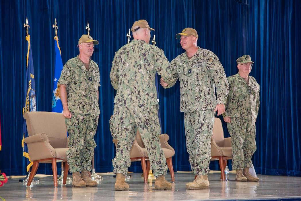 U.S. Navy Rear Adm. Brent DeVore, outgoing commander, Joint Region Marianas, congratulates Rear Adm. Brett Mietus, incoming JRM commander, during a change of command ceremony at Guam High School, May 29.