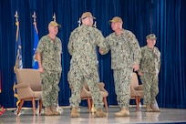 U.S. Navy Rear Adm. Brent DeVore, outgoing commander, Joint Region Marianas, congratulates Rear Adm. Brett Mietus, incoming JRM commander, during a change of command ceremony at Guam High School, May 29.