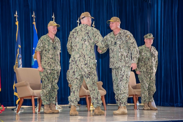 U.S. Navy Rear Adm. Brent DeVore, outgoing commander, Joint Region Marianas, congratulates Rear Adm. Brett Mietus, incoming JRM commander, during a change of command ceremony at Guam High School, May 29.