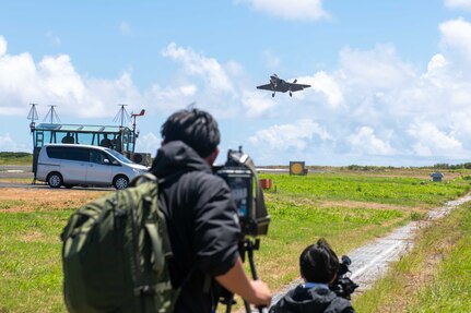Japanese media representatives capture a U.S. Navy F-35C Lightning II assigned to Strike Fighter Squadron (VFA) 147 and attached to Carrier Air Wing (CVW) 5 as the aircraft conducts a “touch-and-go” during a field carrier landing practice (FCLP) at Iwo To, Japan, May 25, 2025.