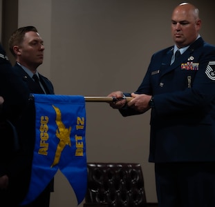 Senior Master Sgt. Jonathan Barron, Air Force Global Strike Command strategic deterrence and nuclear integration member, unwraps the new Detachment guidon at the Site Activation Task Force for Detachment 12. SATAF detachments are tasked with laying the groundwork for Sentinel support operations by overseeing and coordinating transition and establishment activities. (U.S. Air Force photo by Senior Airman Alexander Nottingham)