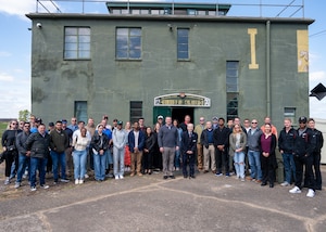 A group of people pose outside the restored Rougham Control Tower museum