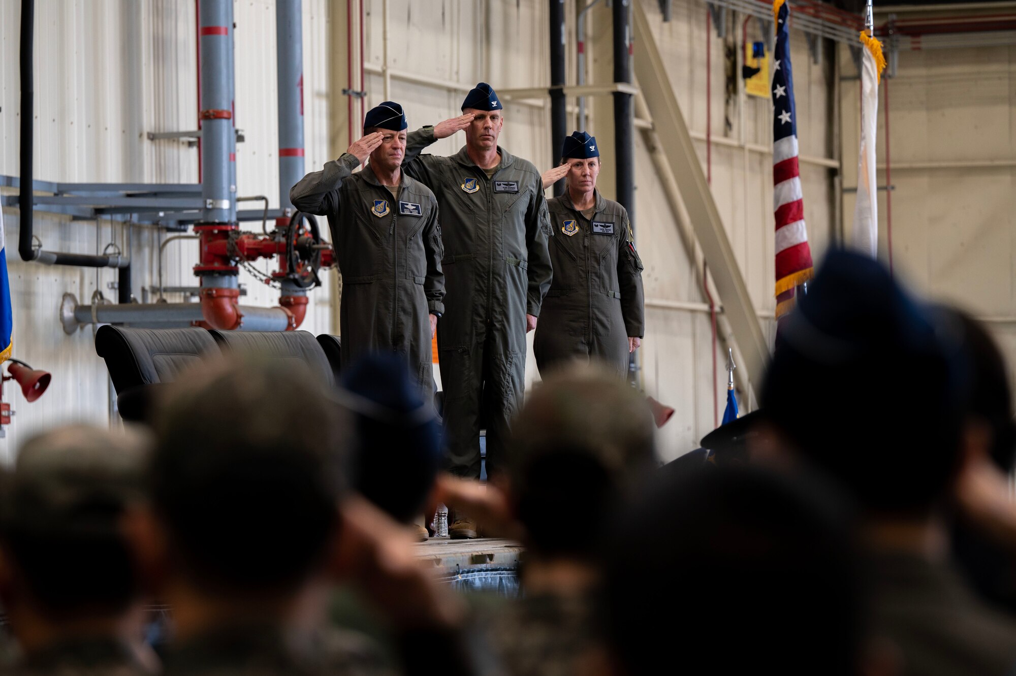 From left to right: U.S. Air Force Lt. Gen. David Iverson, 7th Air Force commander, Col. Peter Kasarskis, and Col. Kathryn Gaetke, render a salute during the national anthem at a change of command ceremony at Kunsan Air Base, Republic of Korea, May 30, 2025.